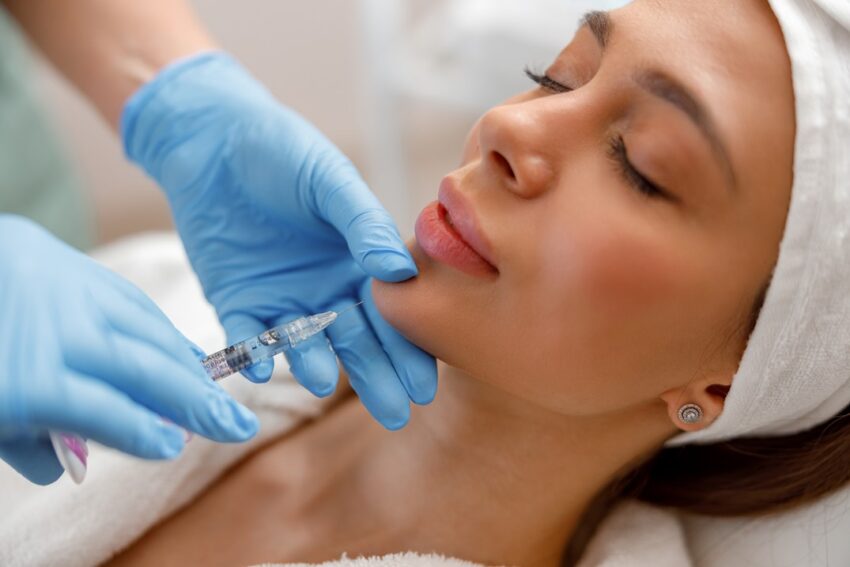 Closeup of young woman receiving hyaluronic acid injection in beauty salon.